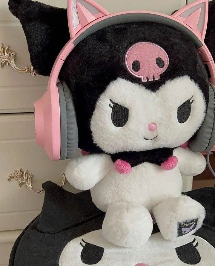 a black and white cat stuffed animal with pink headphones on it's ears