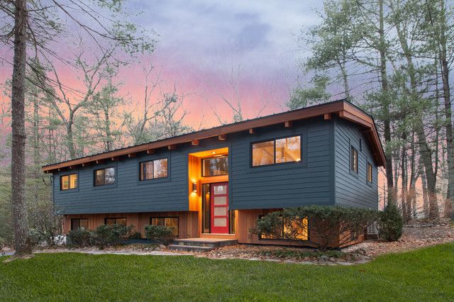 a blue house in the woods at sunset