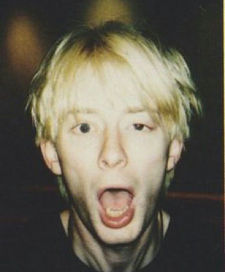 a young man with blonde hair making a face and pulling his tongue out to the side