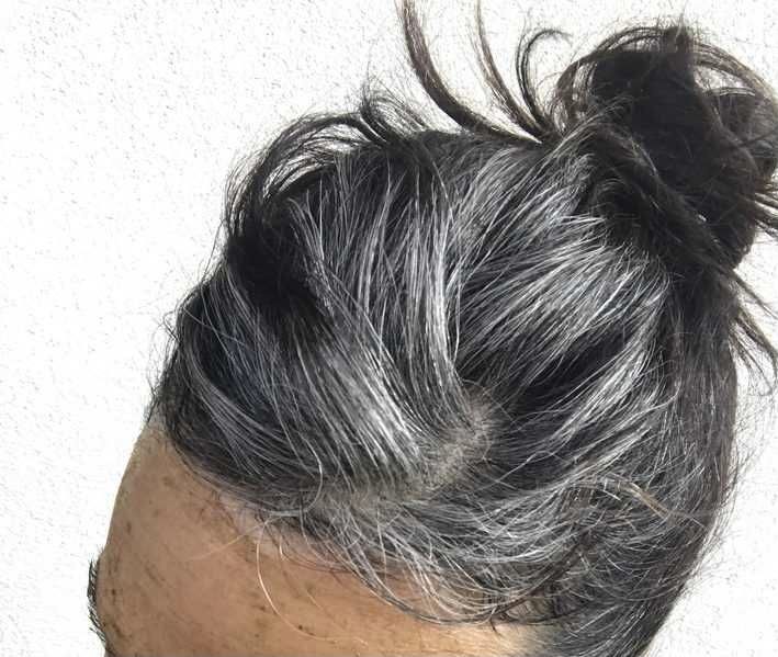 an old man's hair is shown from the top down, with greying and graying on it