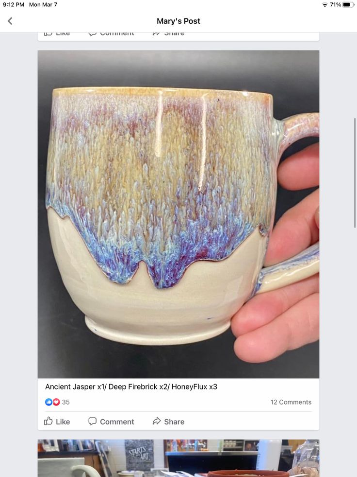 a hand holding a coffee cup with blue and yellow designs on the outside, in front of a facebook page