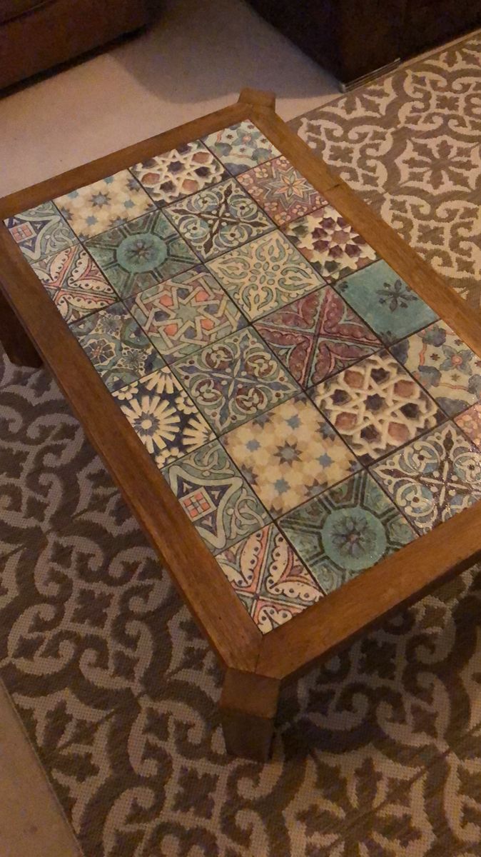 a coffee table that has been decorated with colorful tiles