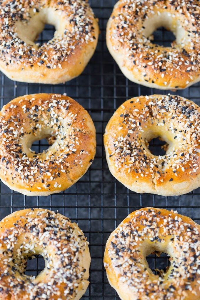 six bagels on a cooling rack with sesame seeds sprinkled on the top