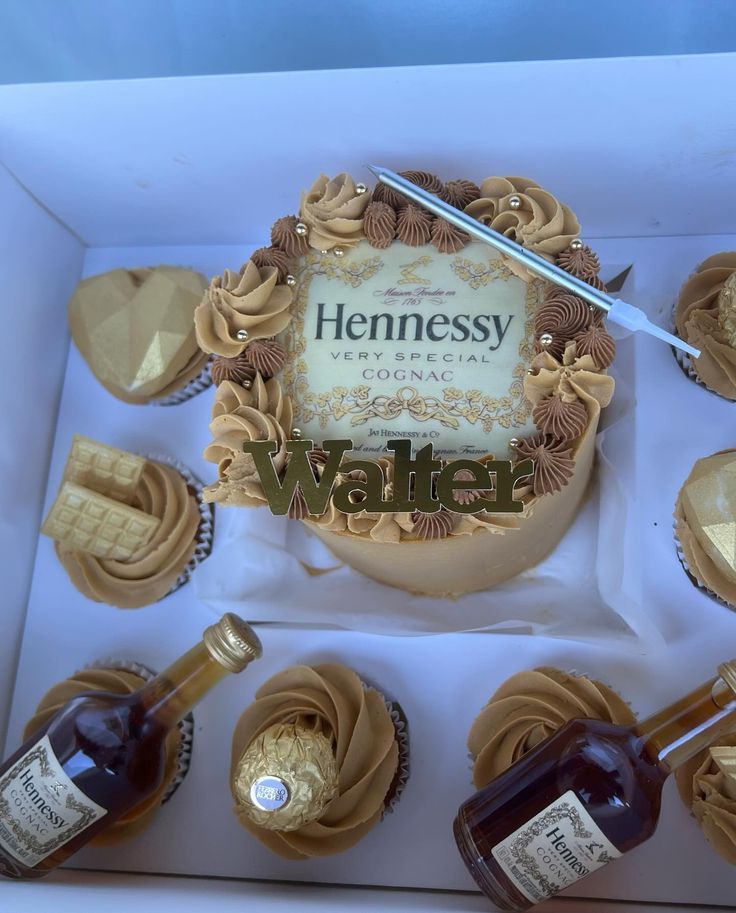 a box filled with cupcakes covered in chocolate frosting and topped with a bottle of hennesy