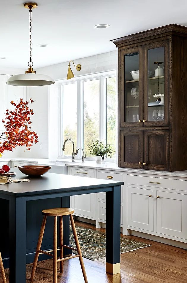 a kitchen with white cabinets and wooden floors