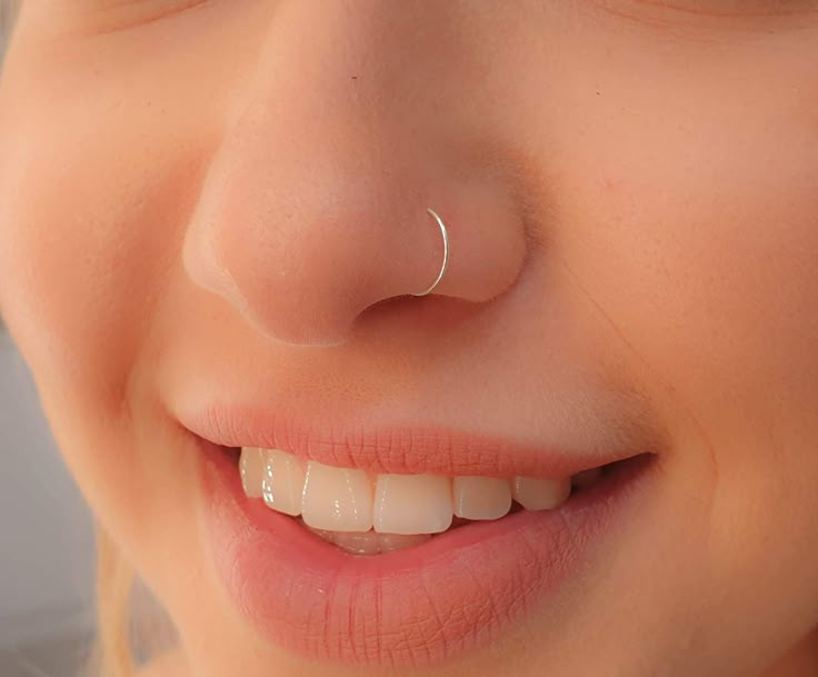 a close up of a child's face with a nose ring on it, smiling