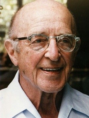 an older man with glasses smiling for the camera