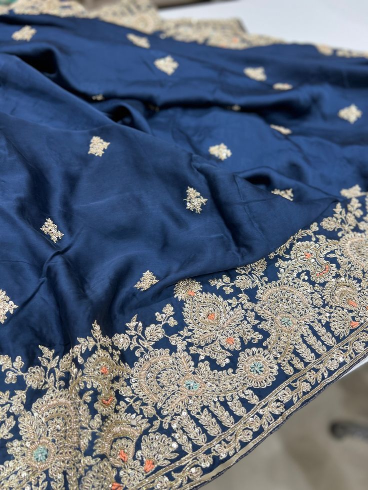 Rise and Shine. A beautiful Pure Satin Silk saree is heavily embellished with hand done Zardozi work. It's a saree which will stand out and it's a must have in your wardrobe this wedding season. Blue satin with Zardosi work make it a very special piece. This saree can be worn for your reception, sangeet or cocktail night and it sure will stand out. Zardozi Saree, Satin Silk Saree, Zardosi Work, Zardozi Work, Cocktail Night, Rise And Shine, Satin Silk, Blue Satin, Wedding Season