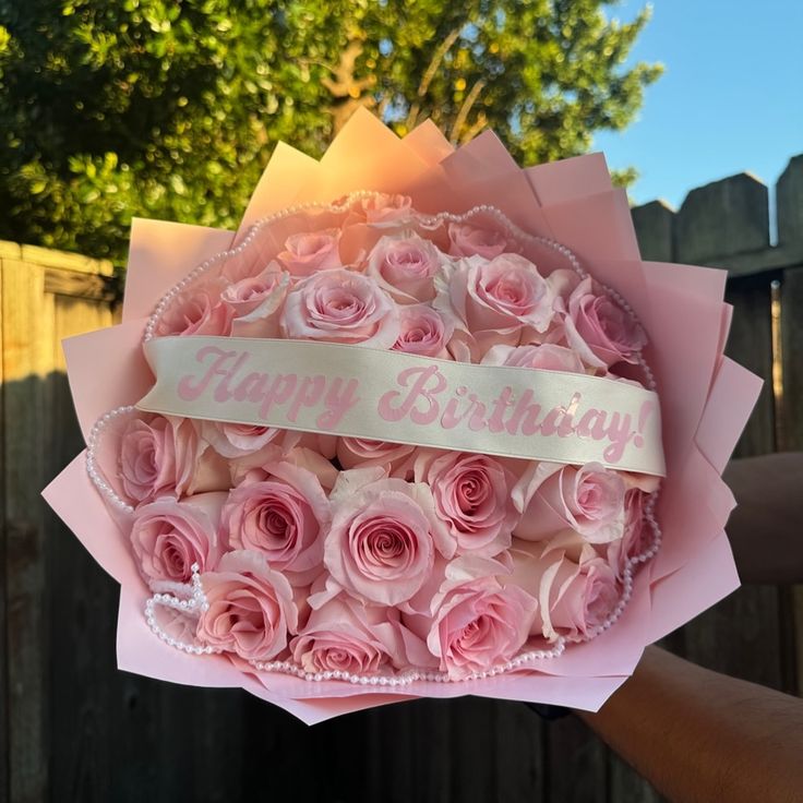 someone is holding a bouquet of pink roses with a happy birthday ribbon on the top