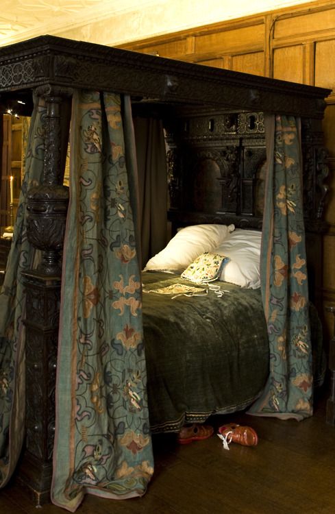 the canopy bed is made up with drapes and curtains on it's sides