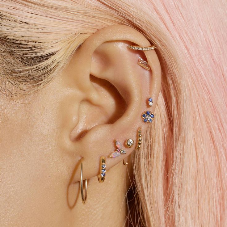 a woman with pink hair wearing ear piercings