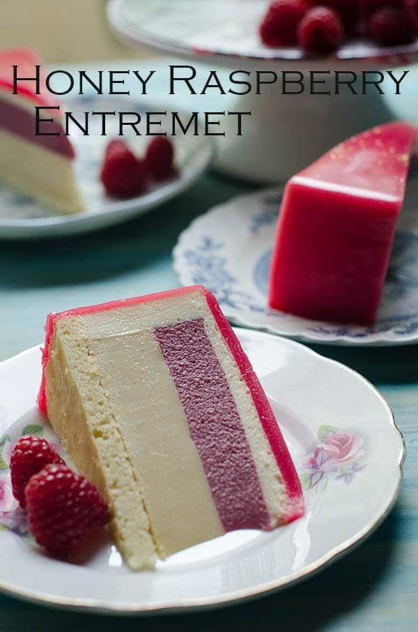 a piece of cake on a plate with raspberries and the words honey raspberry entret