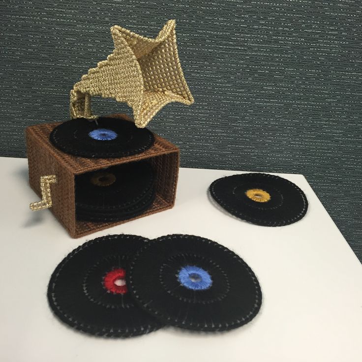 three black records sitting on top of a white table next to a gold star sculpture