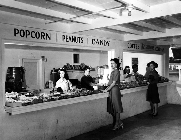 an old black and white photo of people at a candy shop