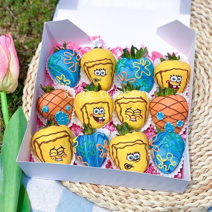 a box filled with decorated strawberries sitting on top of a table