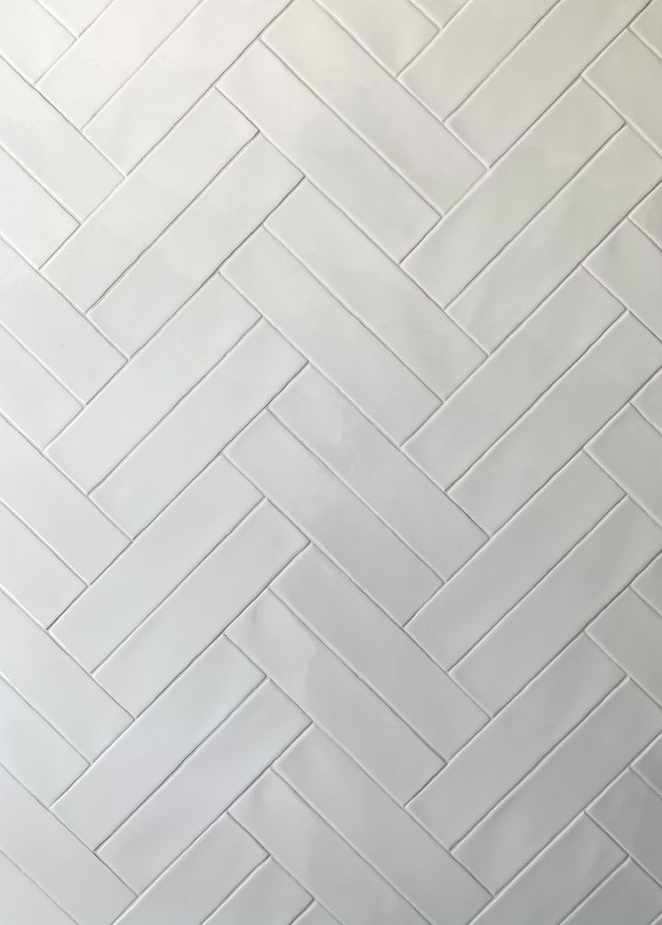 a white tile wall that is very close to the floor and it looks like herringbones