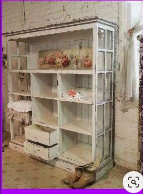 an old white bookcase with flowers on it