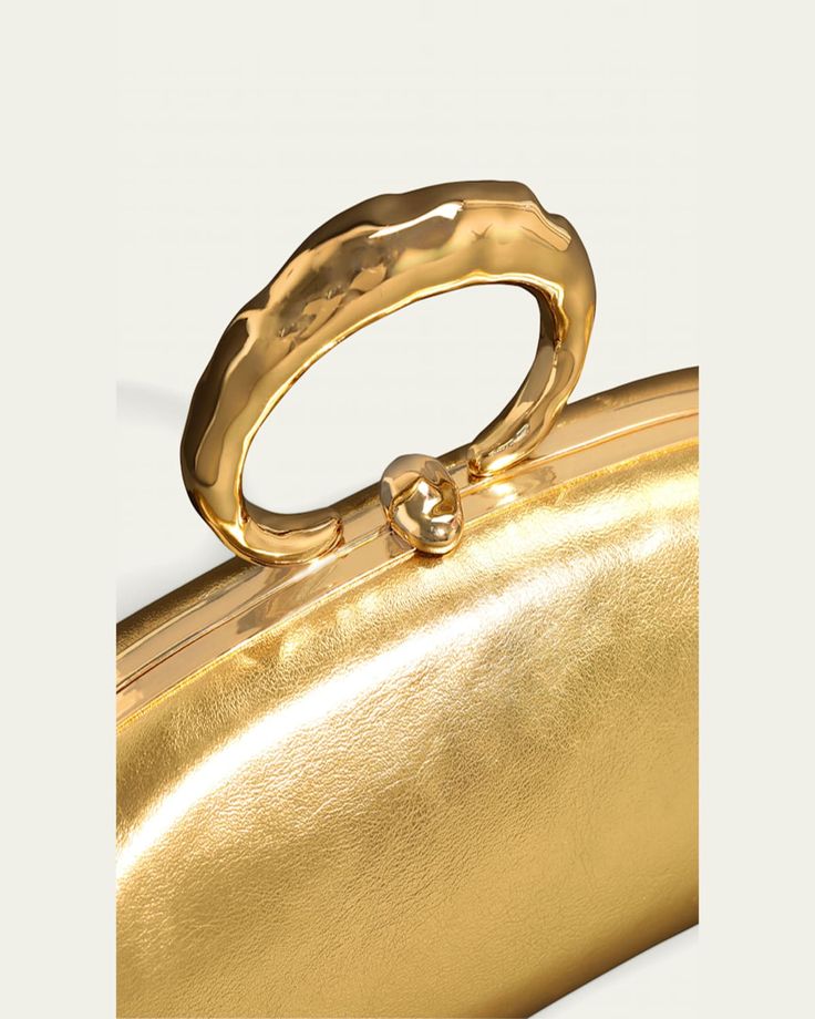 Alexis Bittar "Molton" bullet clutch bag in metallic laminated (high scratch resistance) Italian leather   14karat gold plated brass ring top handle    Can be worn as a top handle or clutch bag    Framed top with liftclasp closure    Lining: PU   Approx. 4"H x 3.5"W x 3.5"D   Item Weight (Lbs.): 1.0   Wipe clean   Imported Molten Gold, Alexis Bittar, Brass Ring, 1 Pound, Metal Rings, Italian Leather, Evening Wear, 4 H, Top Handle