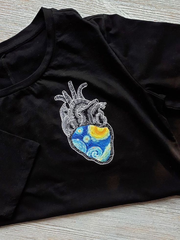 a black t - shirt with an embroidered heart on it