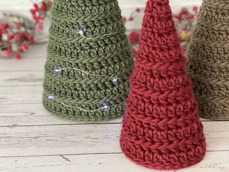 three crocheted christmas trees sitting next to each other