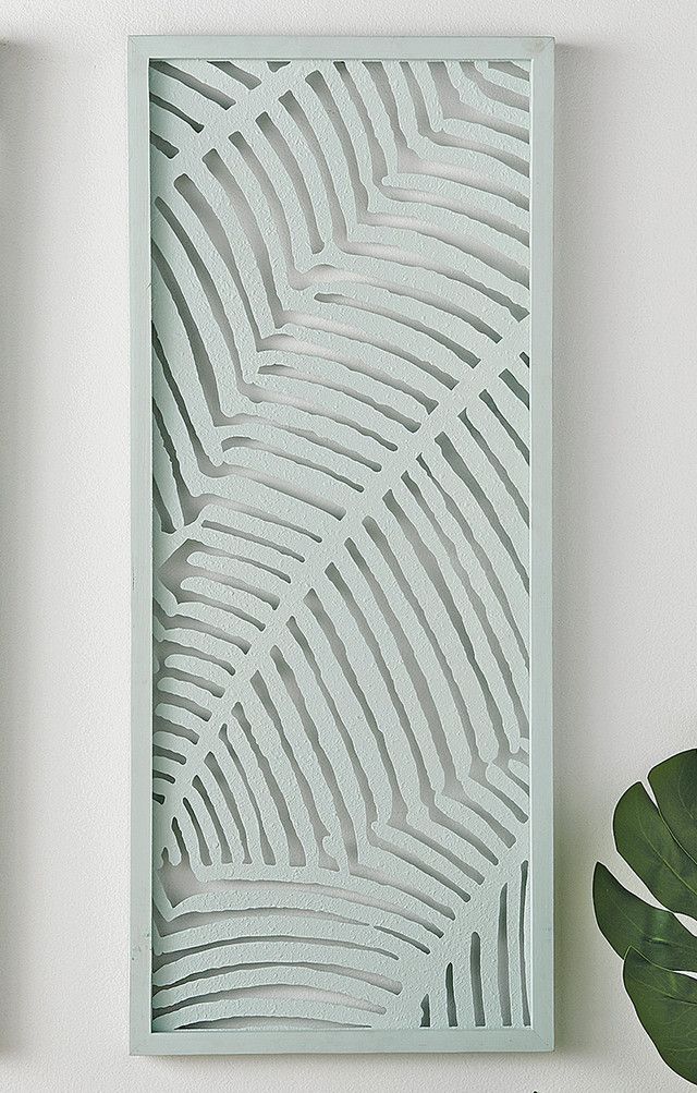 two green plants sit next to each other on a shelf in front of a white wall