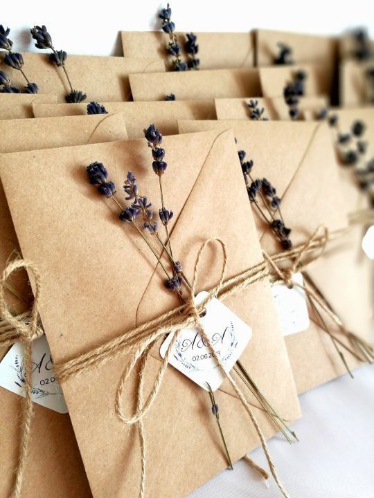 several brown envelopes tied with twine and some lavender flowers are on the table