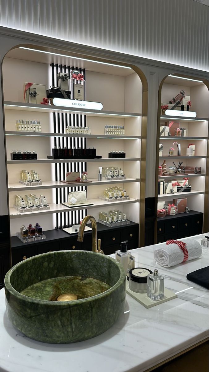 a bathroom sink sitting on top of a counter next to shelves filled with bottles and other items