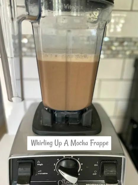 a blender filled with liquid sitting on top of a counter