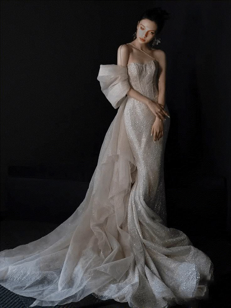 a woman in a white dress standing with her arms around her neck and wearing a veil