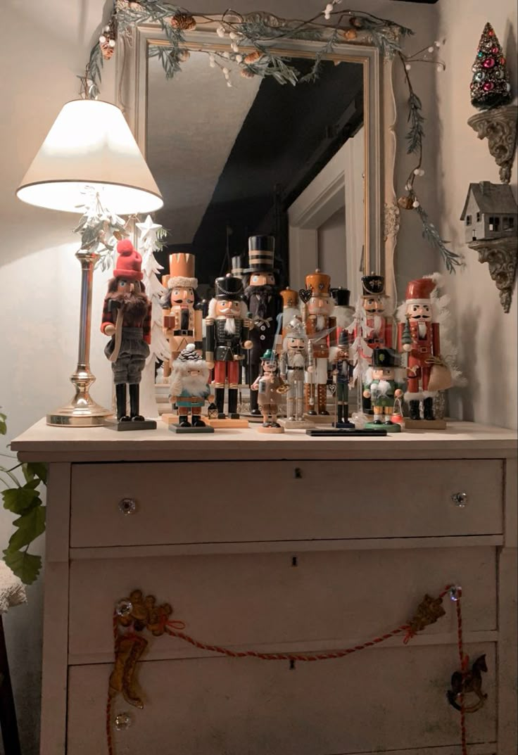 a white dresser topped with lots of figurines on top of it's drawers