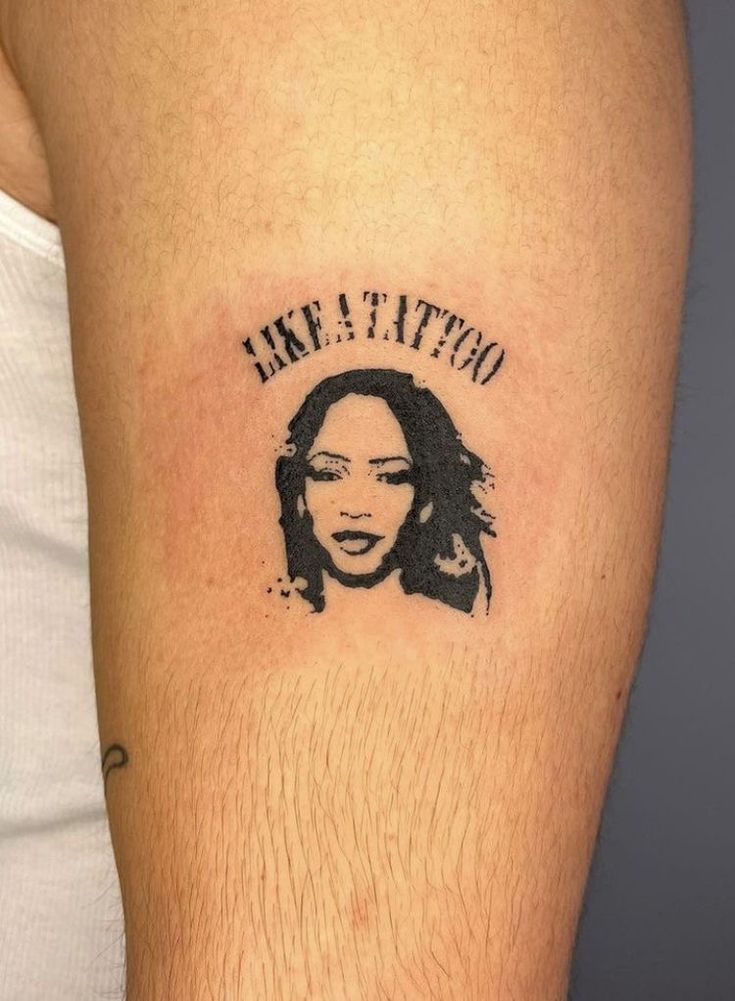 a tattoo on the arm of a man with a woman's face in black ink