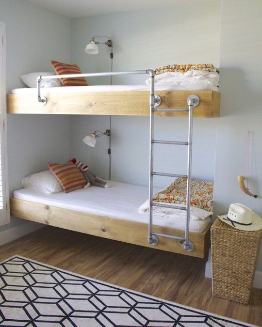 an image of a bedroom with bunk beds on the bottom floor and ladder to the top