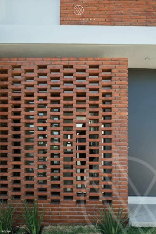 a brick building with an open door and decorative planters on the outside wall, in front of it