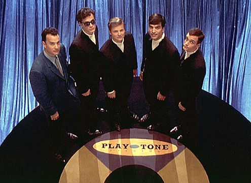 a group of men standing next to each other in front of a sign that says play tone