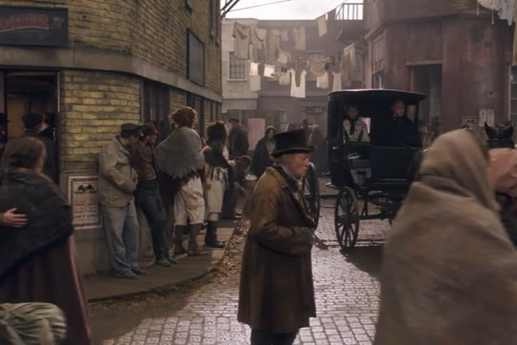 a man in a trench coat and top hat walking down the street with other people