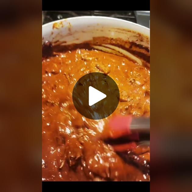 a pan filled with meat and sauce on top of a stove