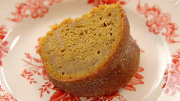 a piece of cake sitting on top of a white and red flowered saucer