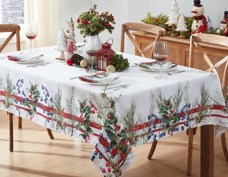 a dining room table with christmas decorations on the table and place settings in front of it