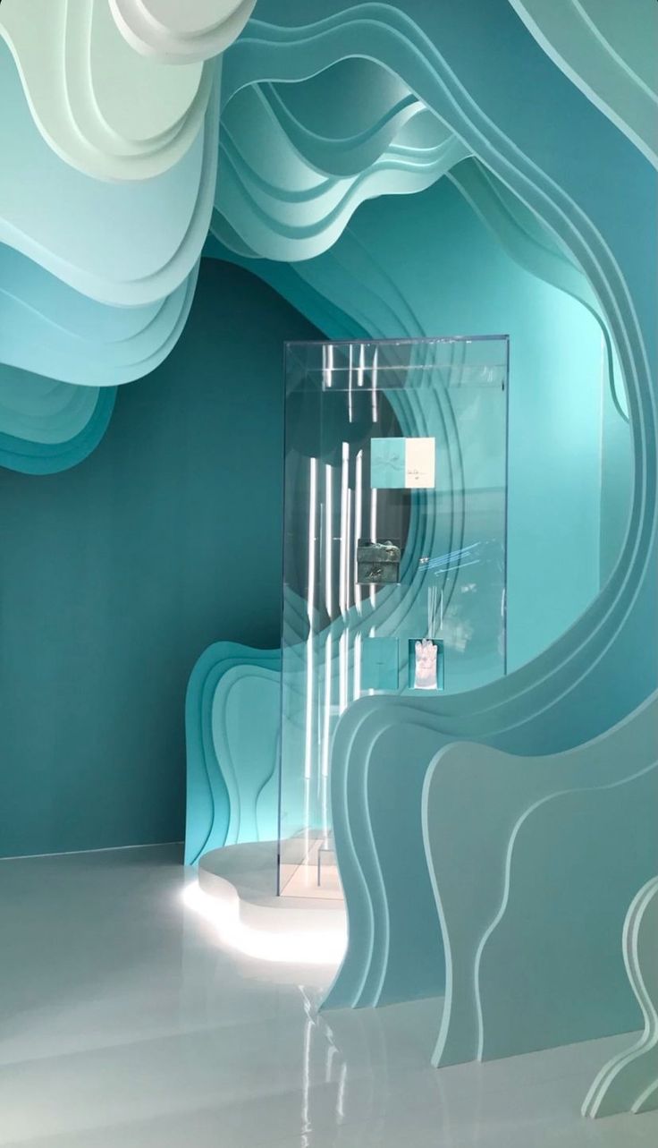 an artisticly designed room with blue and white waves painted on the walls, along with a glass display case