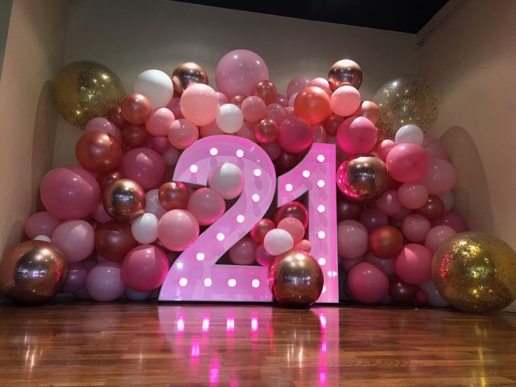 a large number sign surrounded by balloons and streamers