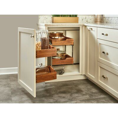 an open cabinet in the corner of a kitchen with drawers and spice jars on it