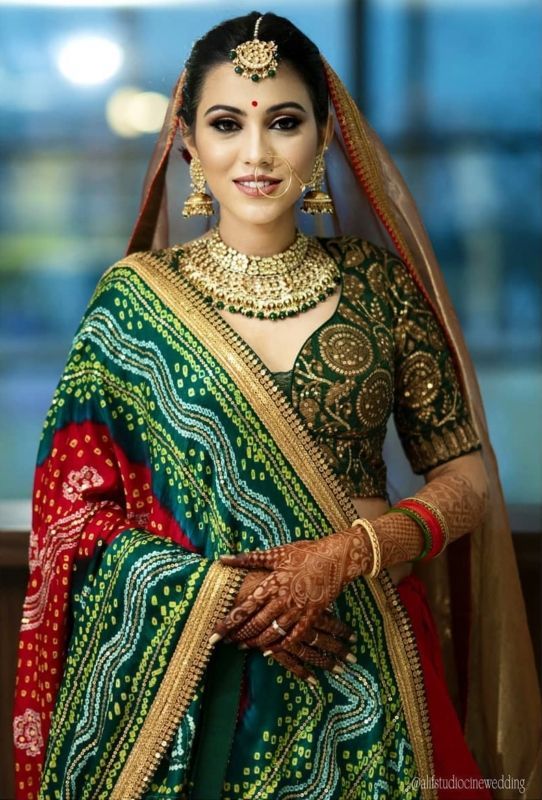 a woman wearing a green and red bridal outfit