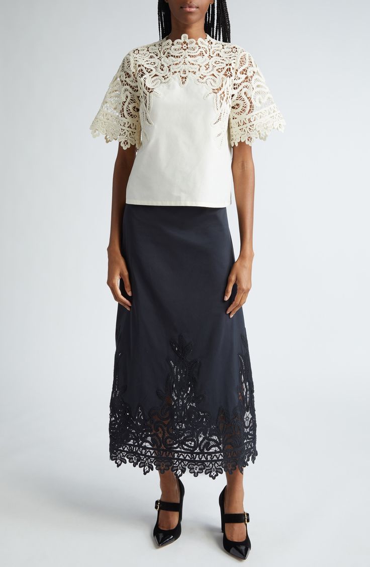 A graceful swirling pattern in guipure lace comprises the yoke and sleeves of this elegant cotton-and-silk top. 22" length (size 8) Back keyhole with button-and-loop closure Jewel neck Short sleeves 70% cotton, 30% silk Dry clean Imported Elegant Cream Lace Top With Lace Collar, Luxury Fitted Embroidered Dola Silk Top, Cream Collared Embroidered Top, Ulla Johnson Knitwear, Ulla Johnson Blouse, Silk Maxi Skirt, Silk Midi Skirt, Lace Midi Skirt, Cotton Midi Skirt