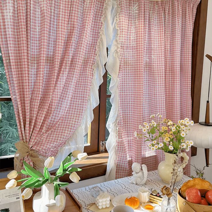 the table is set for breakfast with fresh fruit and flowers in vases on it