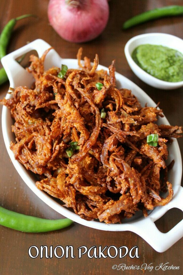 onion pakopa served in a white bowl with green chutneys on the side