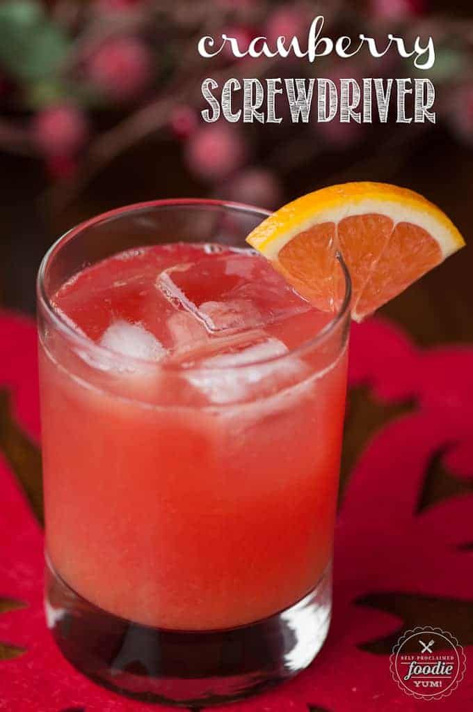 a close up of a drink in a glass with an orange slice on the rim