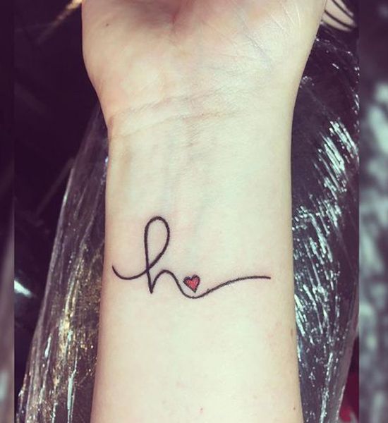 a small wrist tattoo with the word love on it