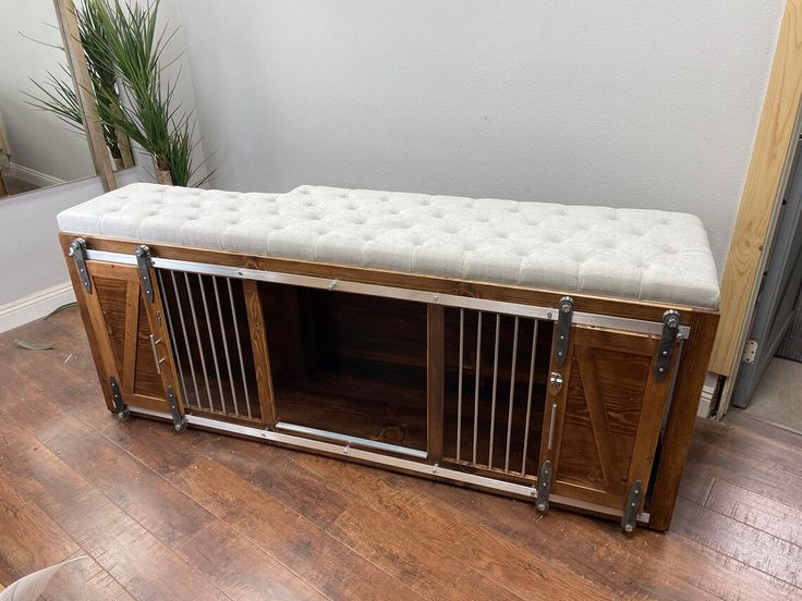 a large wooden dog crate sitting on top of a hard wood floor next to a mirror