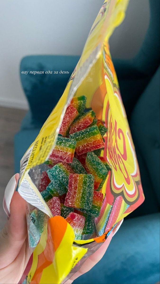 a person holding a bag of gummy bears in their hand with the candy inside