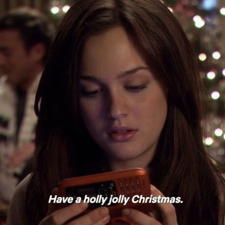 a woman looking at her cell phone with the words have a holly holly christmas on it